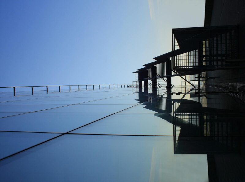 A striking glass skyscraper reflecting blue skies, showcasing modern architecture's elegance.