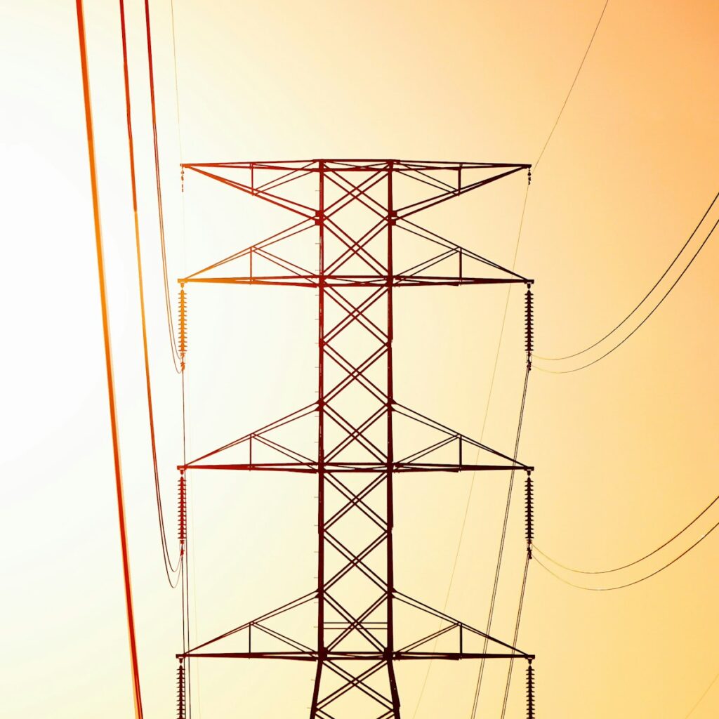 a high voltage power line against an orange sky